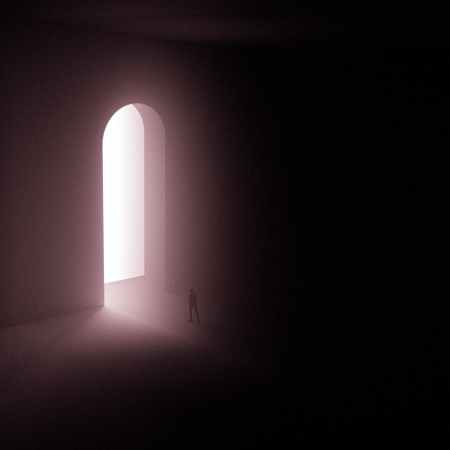 silhouette of person standing near a doorway with bright light